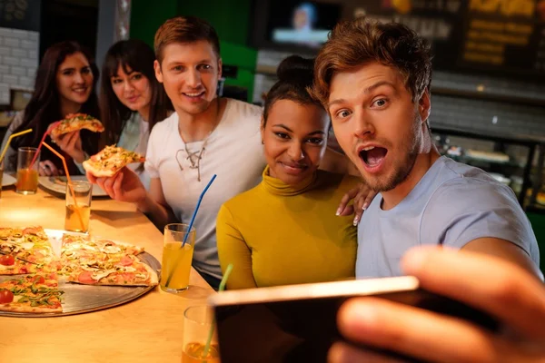 Amici multirazziali si divertono a mangiare pizza in pizzeria . — Foto Stock