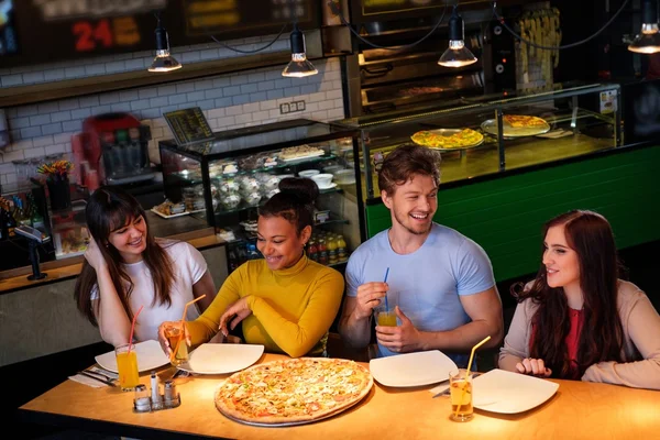 Amigos multirraciales divirtiéndose comiendo pizza en la pizzería . —  Fotos de Stock