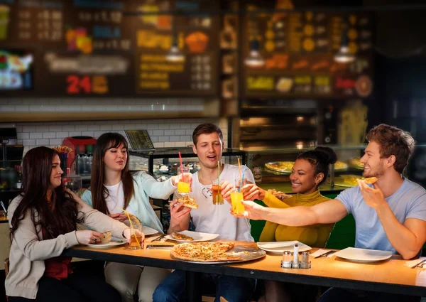 Amici multirazziali si divertono a mangiare pizza in pizzeria . — Foto Stock