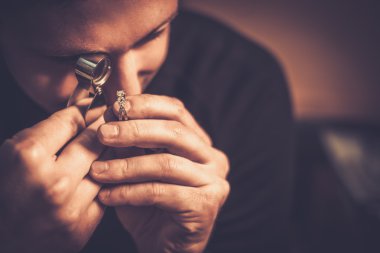 Portrait of a jeweler during the evaluation of jewels.  clipart