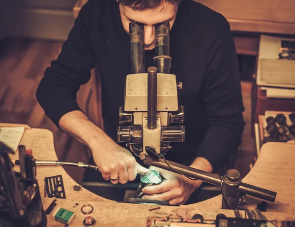 Juvelerare titta på ringen genom Mikroskop i en workshop. — Stockfoto