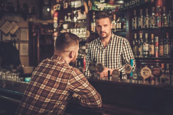 Bir bardak bira bira bir barda müşteriye dökme yakışıklı barmen. — Stok fotoğraf