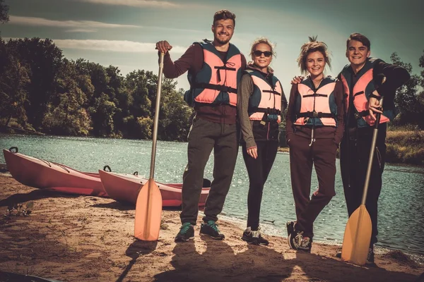 Znajomi, zabawa w kajaki na plaży. — Zdjęcie stockowe