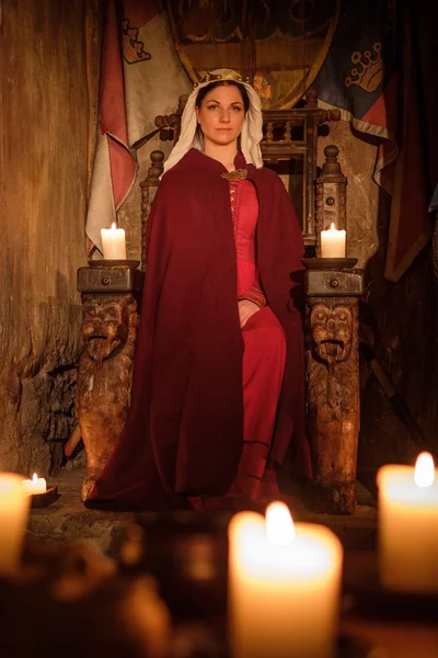 Medieval queen on the throne in ancient castle interior. — Stock Photo, Image