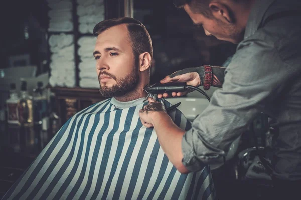 Homem confiante visitando cabeleireiro na barbearia . — Fotografia de Stock