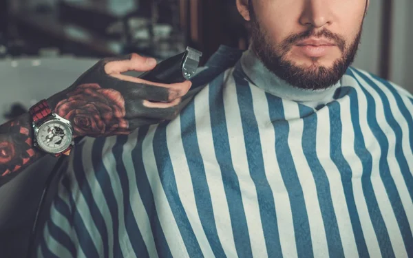 Selbstbewusster Mann besucht Friseur im Friseursalon. — Stockfoto