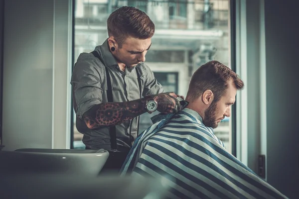 Homem confiante visitando cabeleireiro na barbearia . — Fotografia de Stock