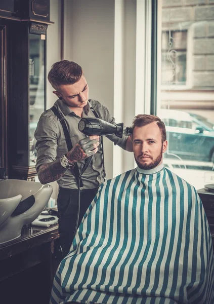 Selbstbewusster Mann besucht Friseur im Friseursalon. — Stockfoto