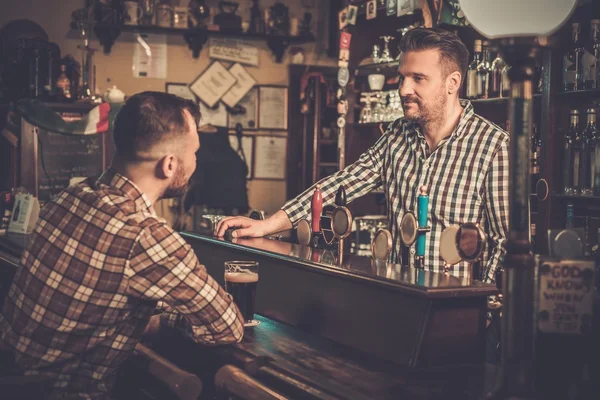 Симпатичный бармен разговаривает с клиентом — стоковое фото