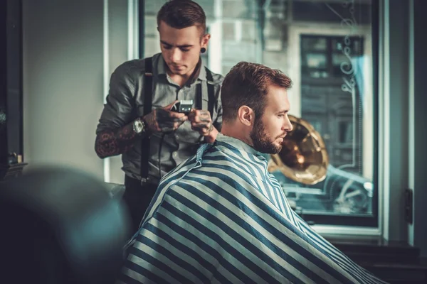Homem visitando cabeleireiro na barbearia . — Fotografia de Stock