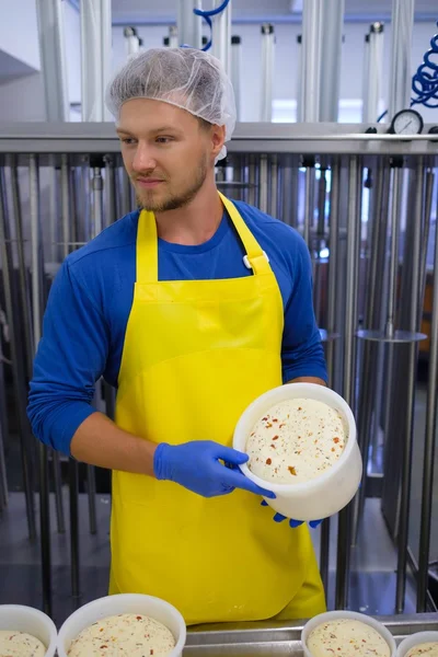 Cheesemaker は、彼のワーク ショップでチーズを作っています。. — ストック写真