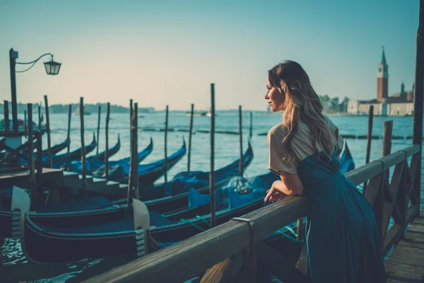 Beautiful well-dressed woman standing near San Marco square with gondolas and Santa Lucia island on the background. — Stock Photo, Image