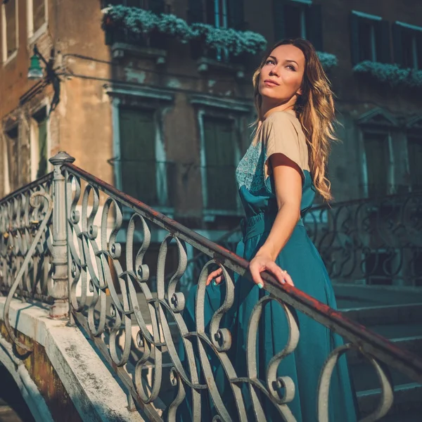 Beautiful well-dressed woman posing on a bridge over the canal in Venice. — Stock Photo, Image