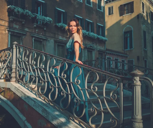 Mooie goed geklede vrouw poseren op een brug over het kanaal in Venetië. — Stockfoto