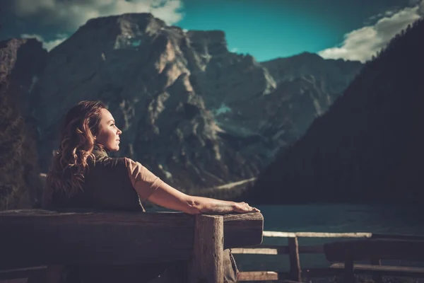 Mulher desfrutando de uma vista incrível do Lago di Braies com floresta de montanha no fundo . — Fotografia de Stock