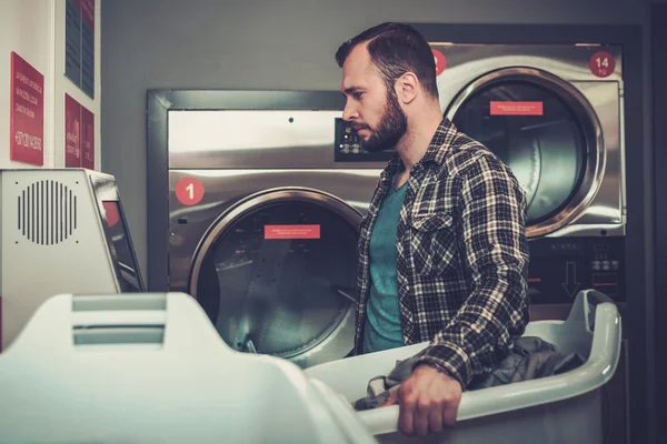 Bonito homem a lavar roupa na lavandaria . — Fotografia de Stock