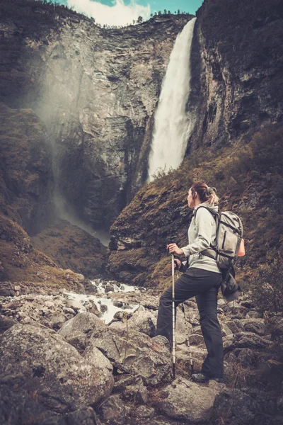 Femme randonneur avec sac à dos debout près de cascade Vettisfossen . — Photo