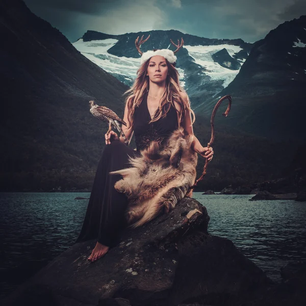 Nordic goddess in ritual garment with hawk near wild mountain lake in Innerdalen valley. — Stock Photo, Image