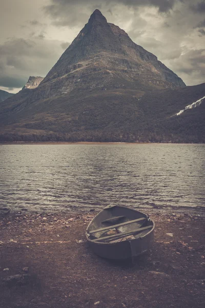 Ensam båt på stranden av vilda fjällsjö, Innerdalen — Stockfoto