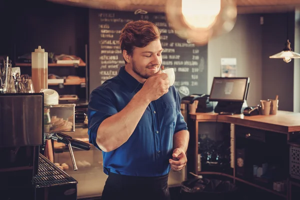 Barista proeven van een nieuwe soort koffie in zijn koffieshop. — Stockfoto