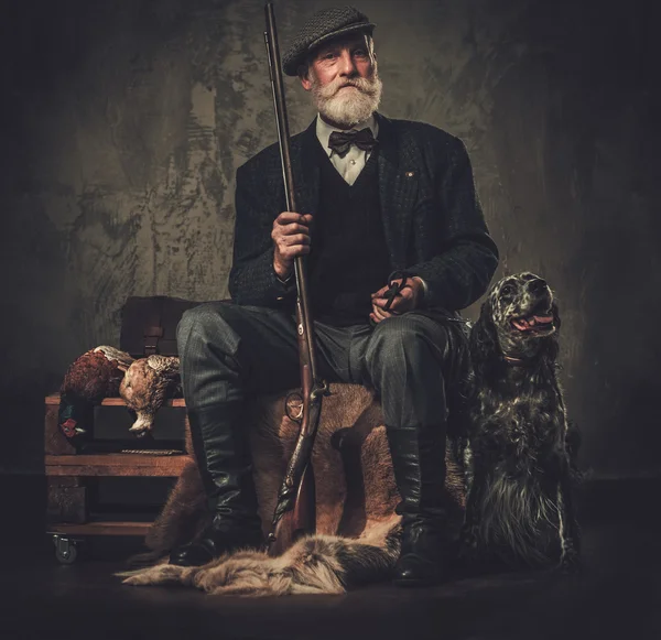 Caçador sênior com um cão de caça inglês e espingarda — Fotografia de Stock