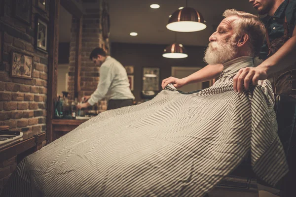 Homem sênior visitando cabeleireiro na barbearia . — Fotografia de Stock