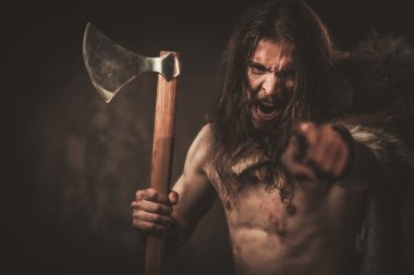 Angry viking with ax in a traditional warrior clothes clipart