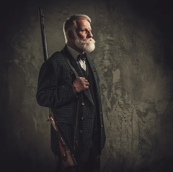 Senior jägare med ett hagelgevär i en traditionell skytte kläder — Stockfoto