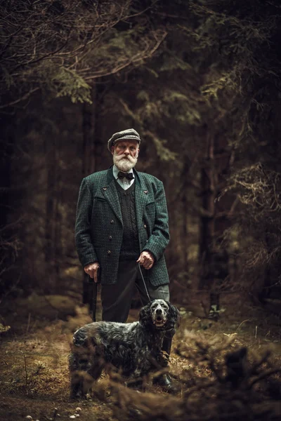 Senior man with dog in a traditional shooting clothing — Stock Photo, Image