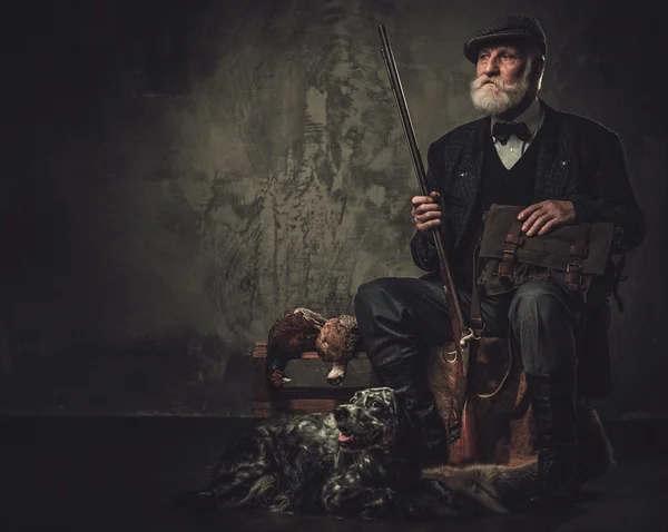 Senior hunter with a english setter and shotgun in a traditional shooting clothing — Stock Photo, Image