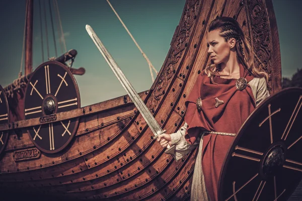 Viking kobieta z mieczem i tarczą, stojący w pobliżu Drakkar — Zdjęcie stockowe