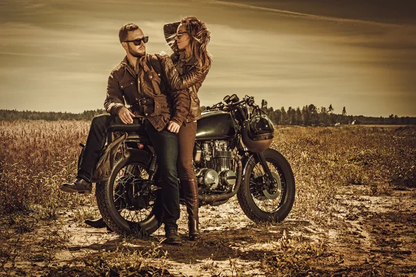 Stylish cafe racer couple on the vintage custom motorcycle — Stock Photo, Image