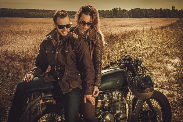 Stylish cafe racer couple on the vintage custom motorcycle — Stock Photo, Image