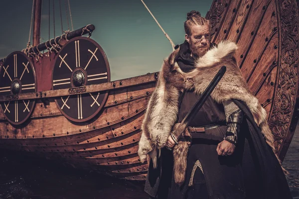 Viking warrior with sword standing near Drakkar — Stock Photo, Image