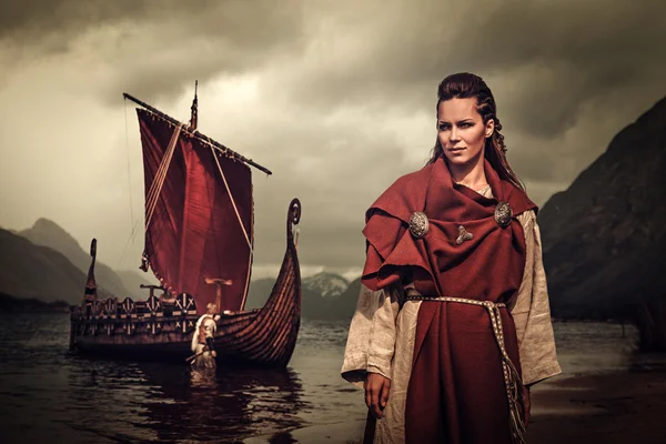 剣と盾海岸でドラッカーの近くに立ってバイキング女性. — ストック写真