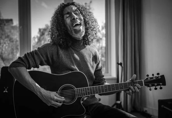 Чорна людина в роках співає і грає на гітарі . — стокове фото