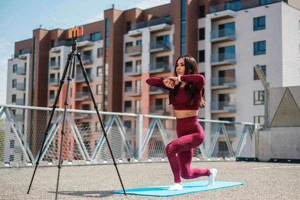 Sportvrouw zorgt voor online training buiten — Stockfoto