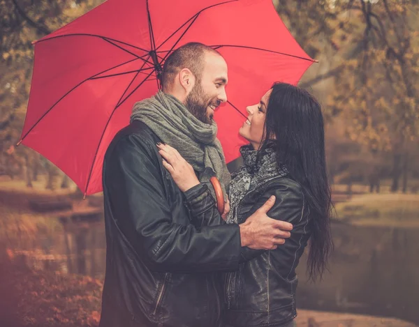Feliz casal de meia-idade com guarda-chuva ao ar livre no belo dia chuvoso de outono — Fotografia de Stock