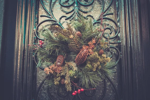 Corona de Navidad con conos colgando de una puerta —  Fotos de Stock