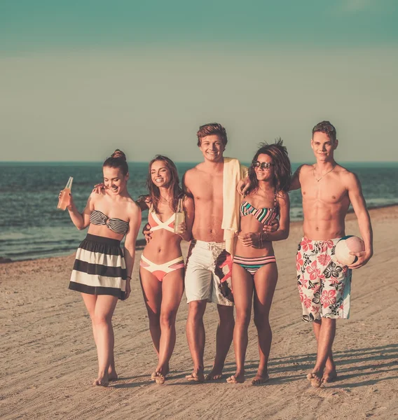 Groupe d'amis multiethniques marchant sur une plage — Photo