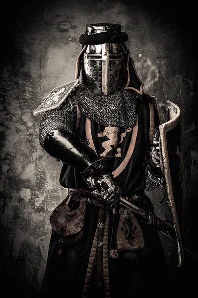Caballero medieval con espada contra muro de piedra —  Fotos de Stock
