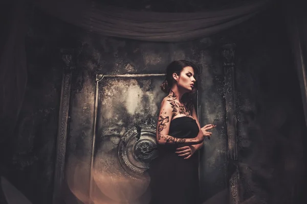 Κάπνισμα τατουάζ όμορφη γυναίκα στο παλιό ντυμένοι φαντάσματα εσωτερικό — Φωτογραφία Αρχείου