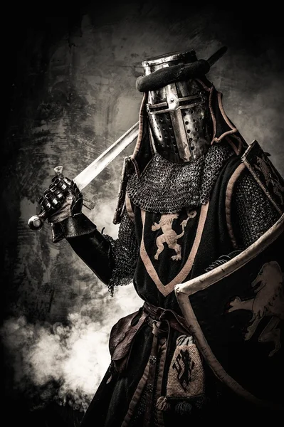 Středověký rytíř s mečem proti kamenné zdi — Stock fotografie