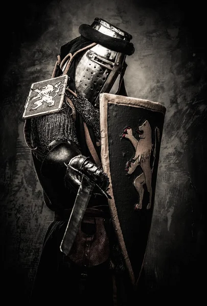 Medieval knight with a sword against stone wall — Stock Photo, Image