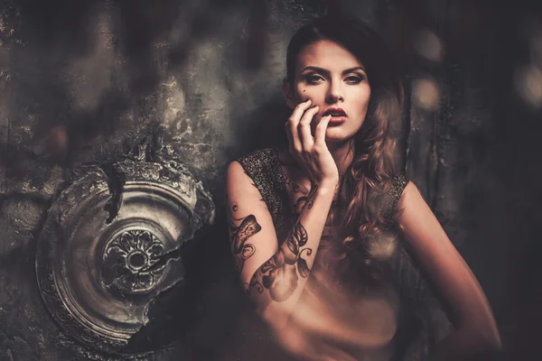 Tattooed beautiful woman in old spooky interior — Stock Photo, Image