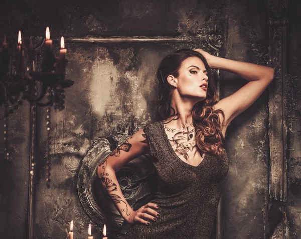 Tattooed beautiful woman in old spooky interior — Stock Photo, Image