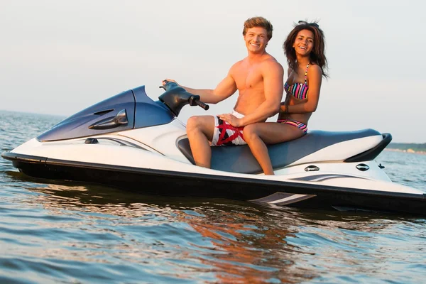 Multi etnische paar zittend op een jet ski — Stockfoto