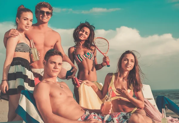 Grupo de amigos multiétnicos con bebidas relajantes en una playa —  Fotos de Stock