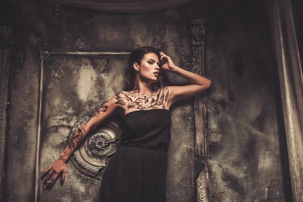 Tattooed beautiful woman in old spooky interior — Stock Photo, Image