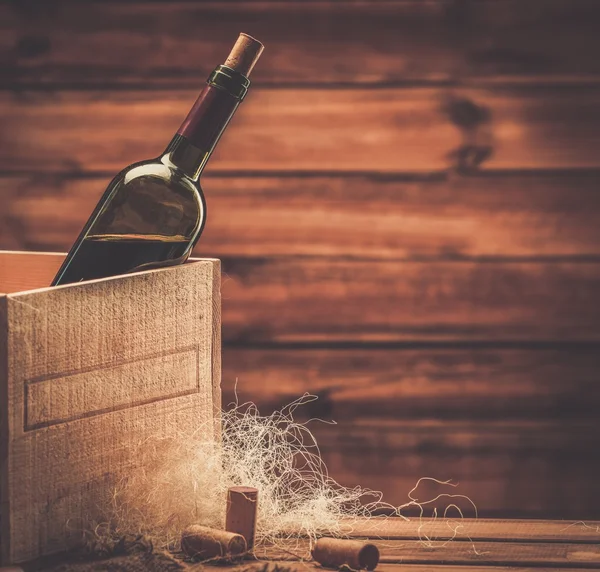 Bottle of wine in box in wooden interior — Stock Photo, Image